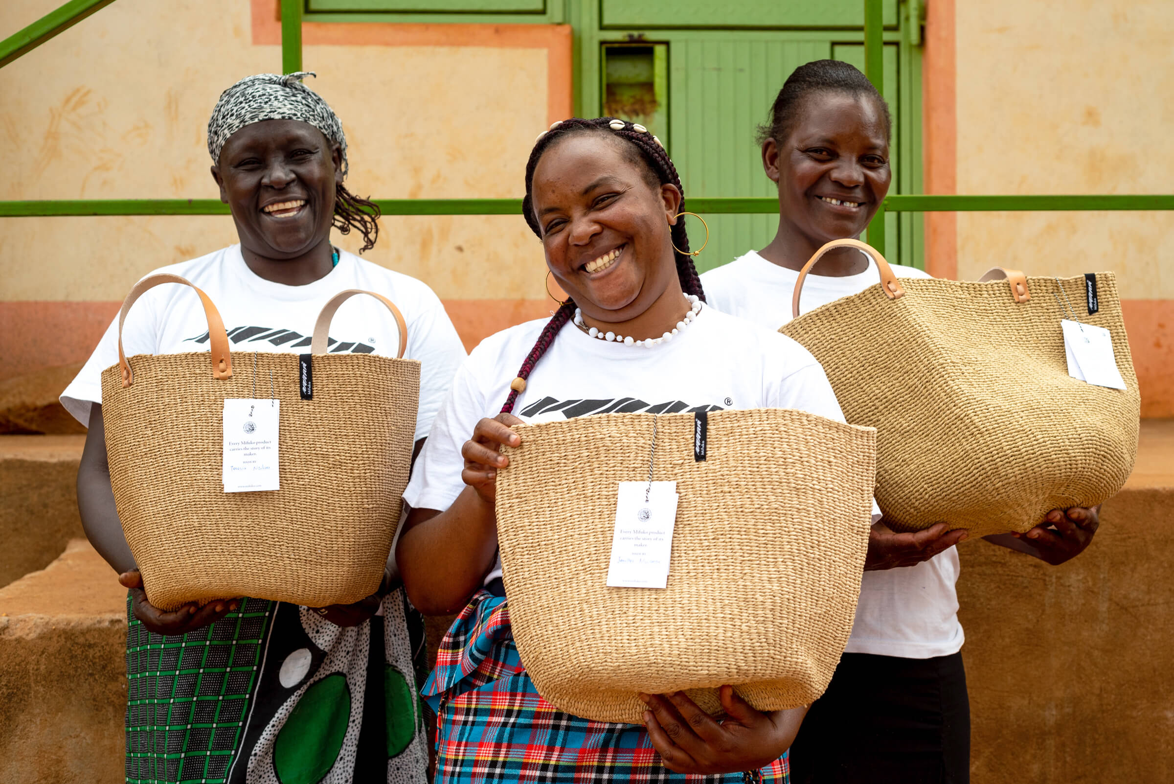 Three Kenyan women holding handmade baskets