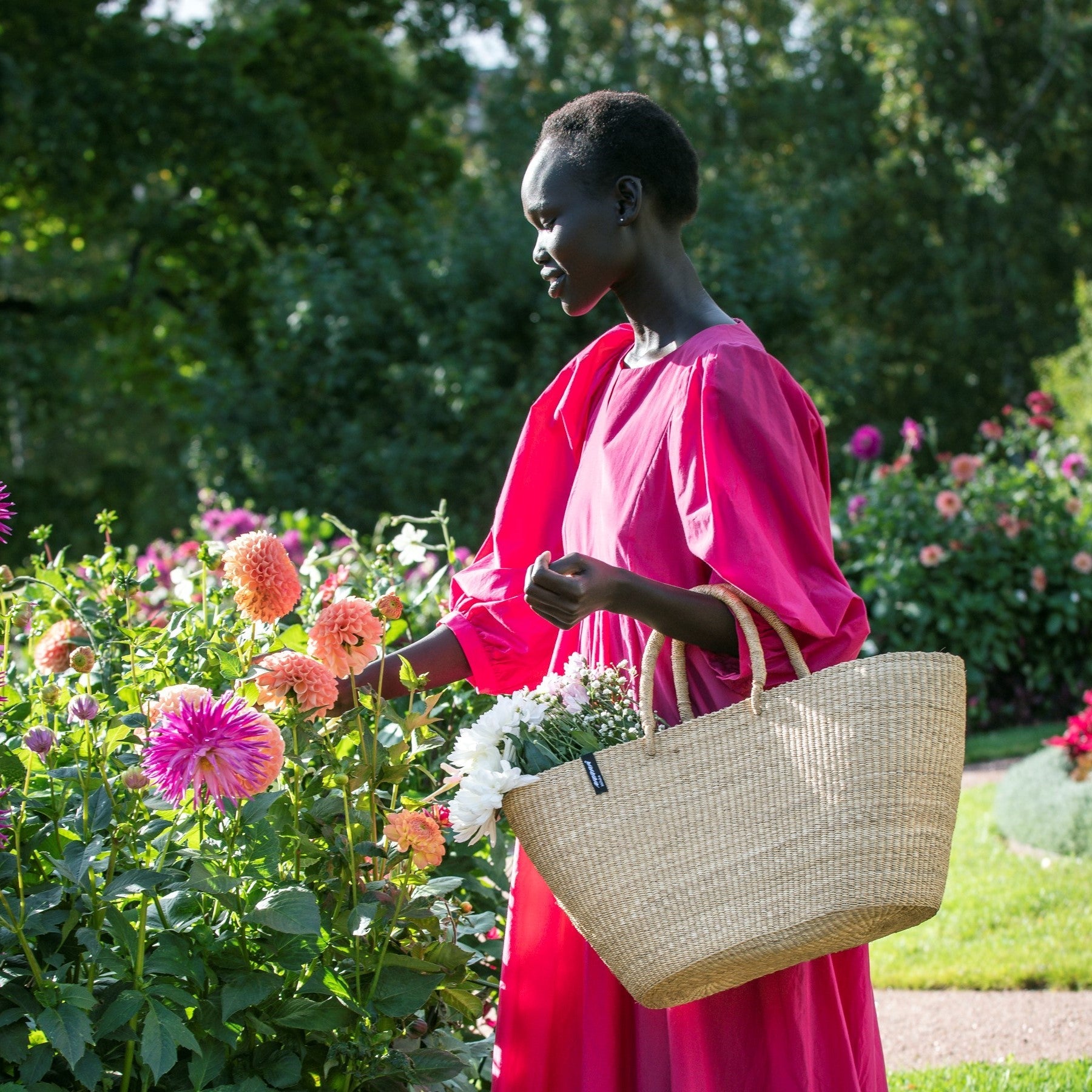 Woman modelling Bolga basket by Mifuko.