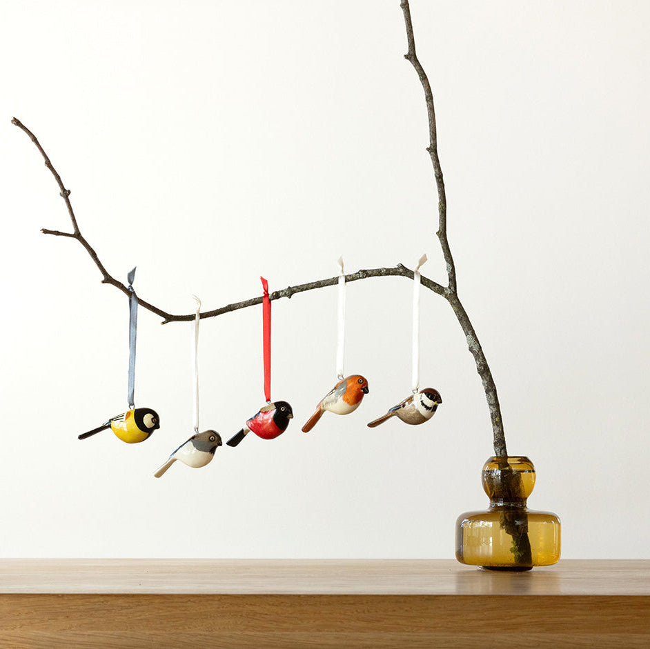 wooden finnish bird ornaments in a branch handmade fair trade