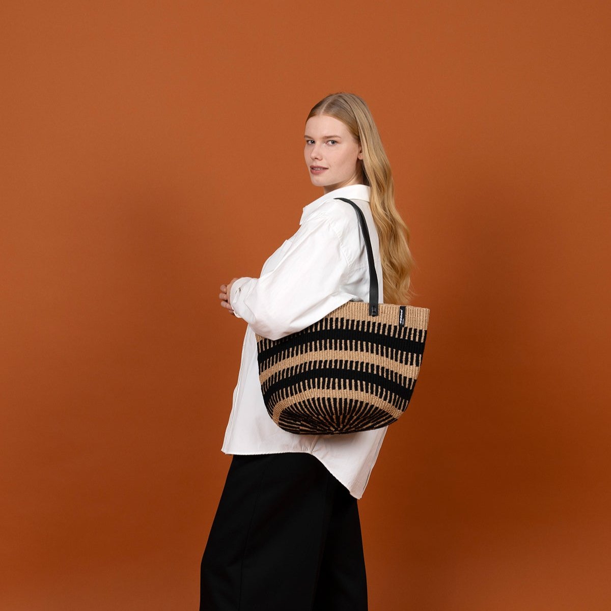 The Pamba shoulder bag is a stylish and durable accessory that combines functionality and elegance. Carefully handwoven, this bag stands out with its unique black rib weave, adding a modern touch to its timeless design.