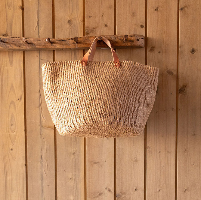 Woven bag hanging on a wooden wall