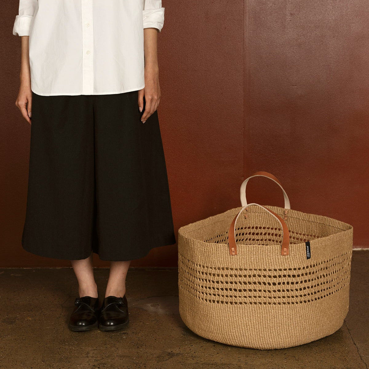 The Kiondo floor basket in brown open weave is a stylish and sustainable storage solution for your home. Handwoven with care by skilled artisans, this extra-large basket is crafted from FSC-certified paper, offering a lightweight yet durable design that is both functional and eco-friendly