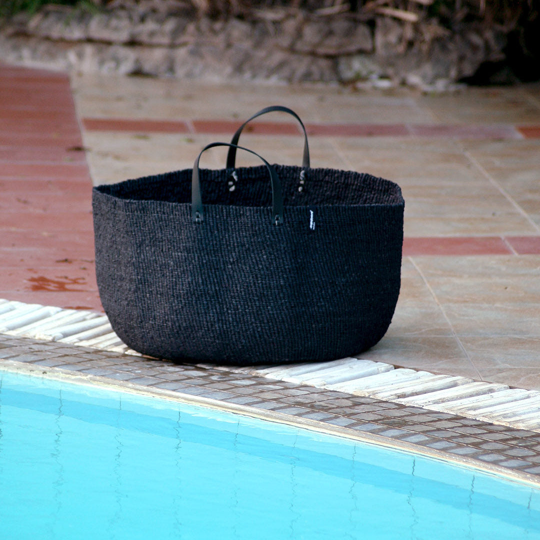 Black towel basket by the pool
