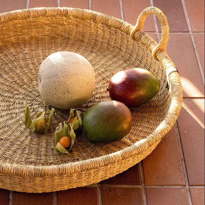 Woven basket with fruits on a tiled floor