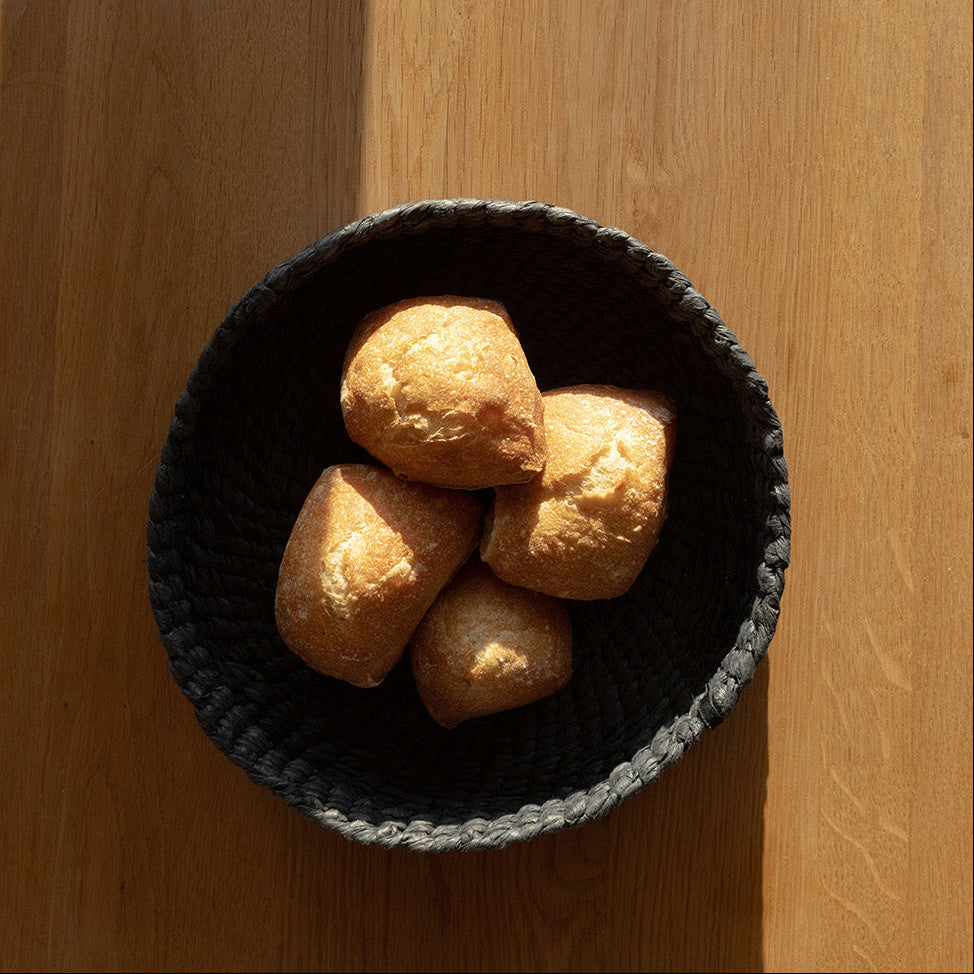 Bowl of bread on a wooden surface with a striped background