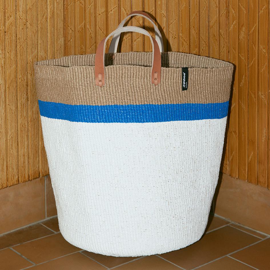 The Kiondo Market Basket with a striking top stripe in blue is a beautiful and practical accessory that combines traditional craftsmanship with modern design. Handwoven with care by skilled artisans, this large basket is made from a unique blend of FSC-certified paper and upcycled plastic, making it lightweight, durable, and environmentally conscious.