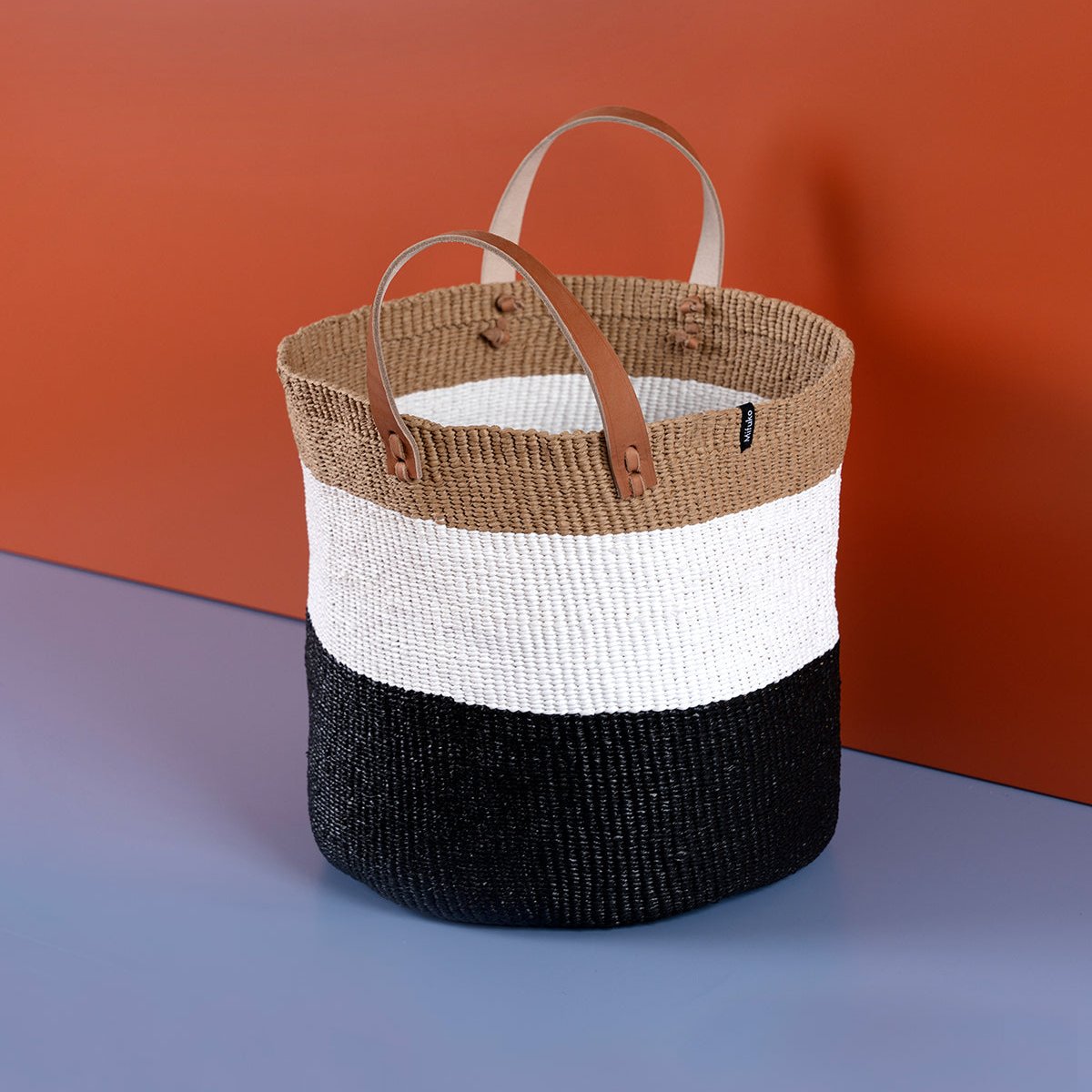 The Kiondo Market Basket in Duo Black is a stylish and sustainable accessory that combines functionality and modern design. Handwoven with care by skilled artisans, this medium-sized basket is crafted from a durable blend of FSC-certified paper and recycled plastic, making it lightweight, robust, and eco-friendly.