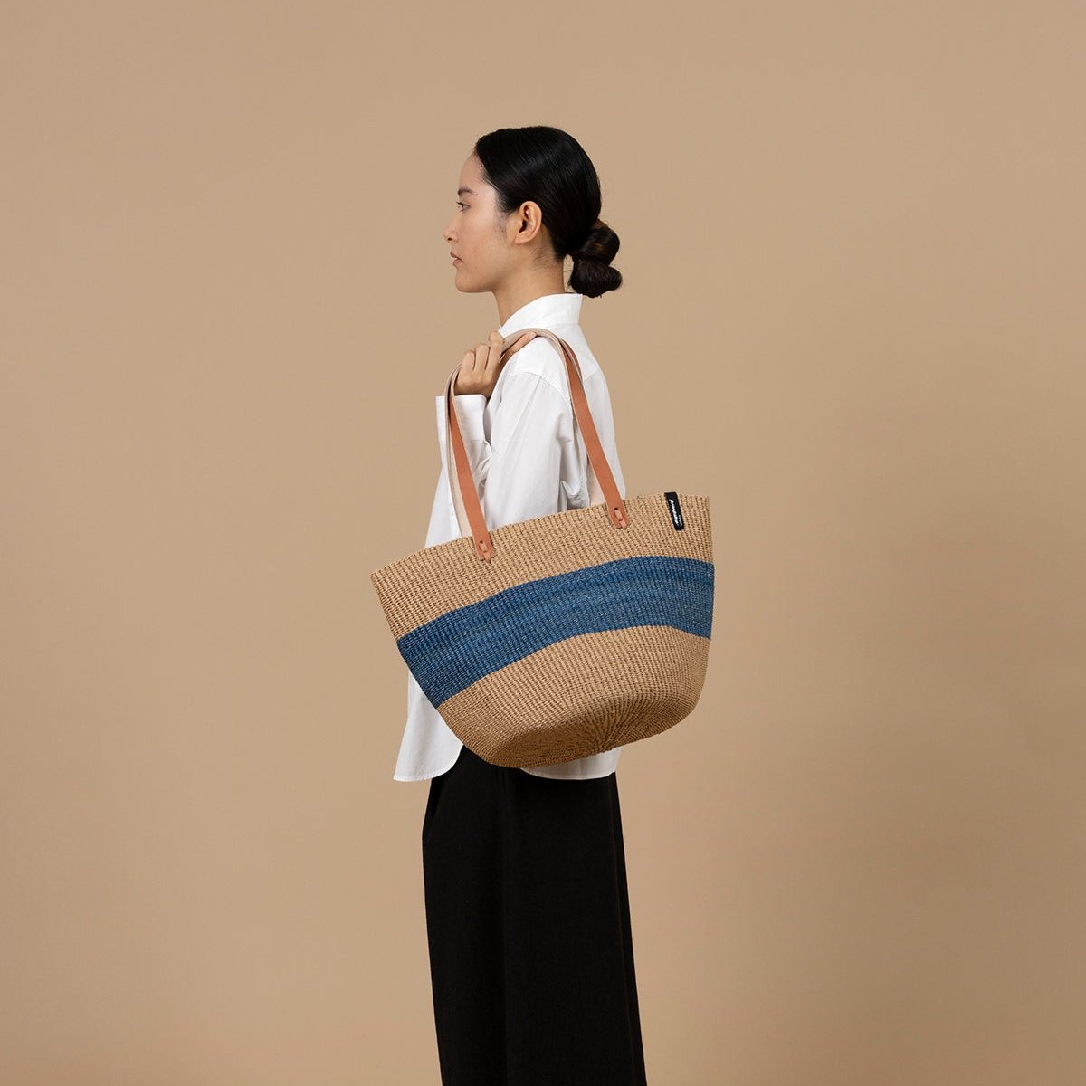 The Majani shopper basket is a beautiful and versatile accessory, handwoven with care using a combination of lightweight, durable paper fiber and soft, eco-friendly banana fiber
