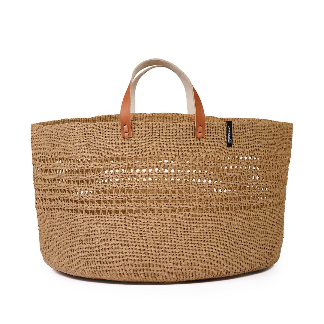 The Kiondo floor basket in brown open weave is a stylish and sustainable storage solution for your home. Handwoven with care by skilled artisans, this extra-large basket is crafted from FSC-certified paper, offering a lightweight yet durable design that is both functional and eco-friendly.