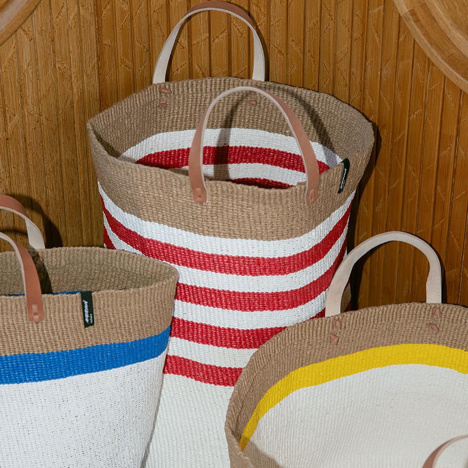 The Kiondo floor basket with elegant thin red stripes is a versatile and stylish storage solution for your home. Handwoven with care by skilled artisans, this extra-large basket is made from FSC-certified paper and upcycled plastic, combining lightweight durability with a commitment to sustainability.