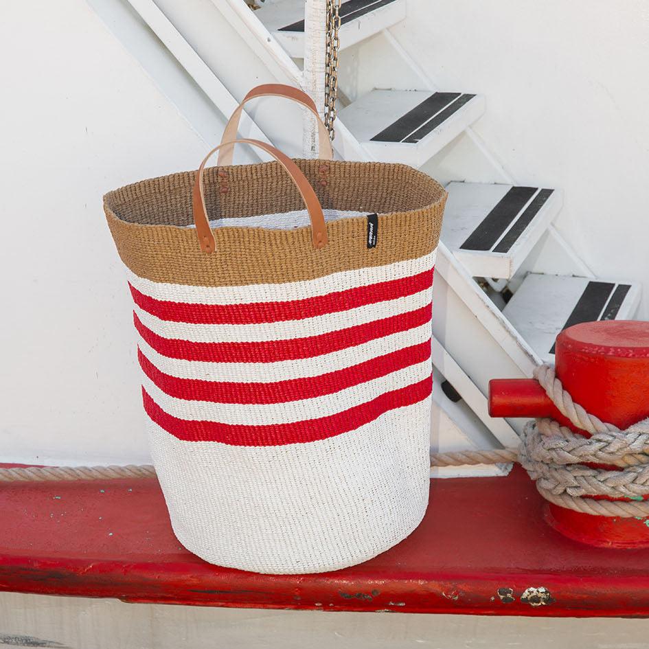 The Kiondo floor basket with elegant thin red stripes is a versatile and stylish storage solution for your home. Handwoven with care by skilled artisans, this extra-large basket is made from FSC-certified paper and upcycled plastic, combining lightweight durability with a commitment to sustainability.