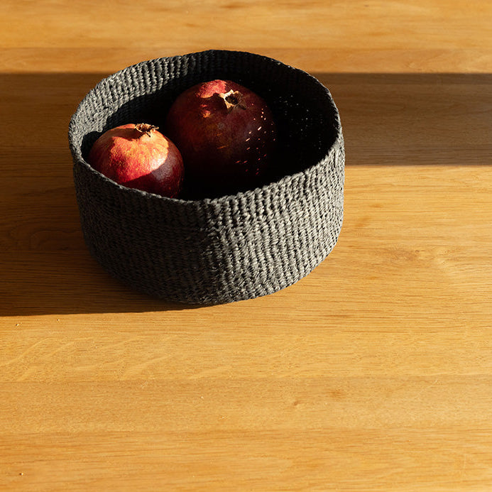 Small woven basket with apples on a wooden table