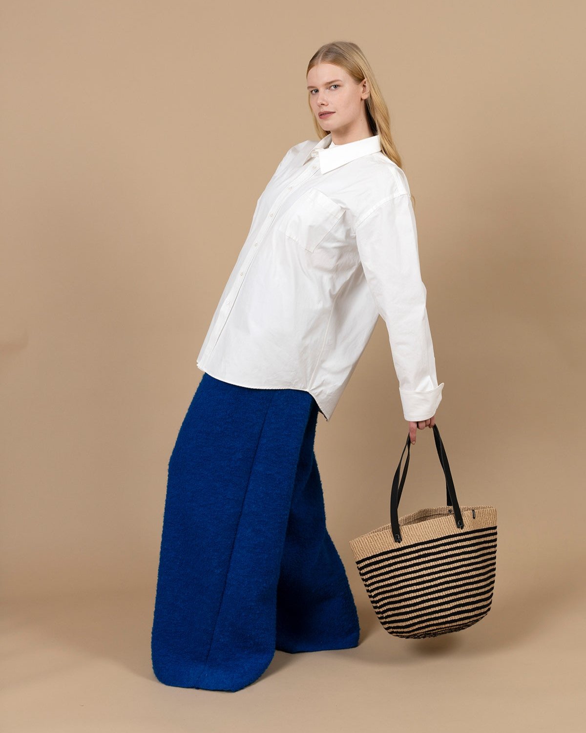 The Pamba shopper basket is a perfect blend of style, functionality, and sustainability. Handwoven with care, this medium-sized basket features a chic black thin stripe design, adding a touch of sophistication to its timeless look.