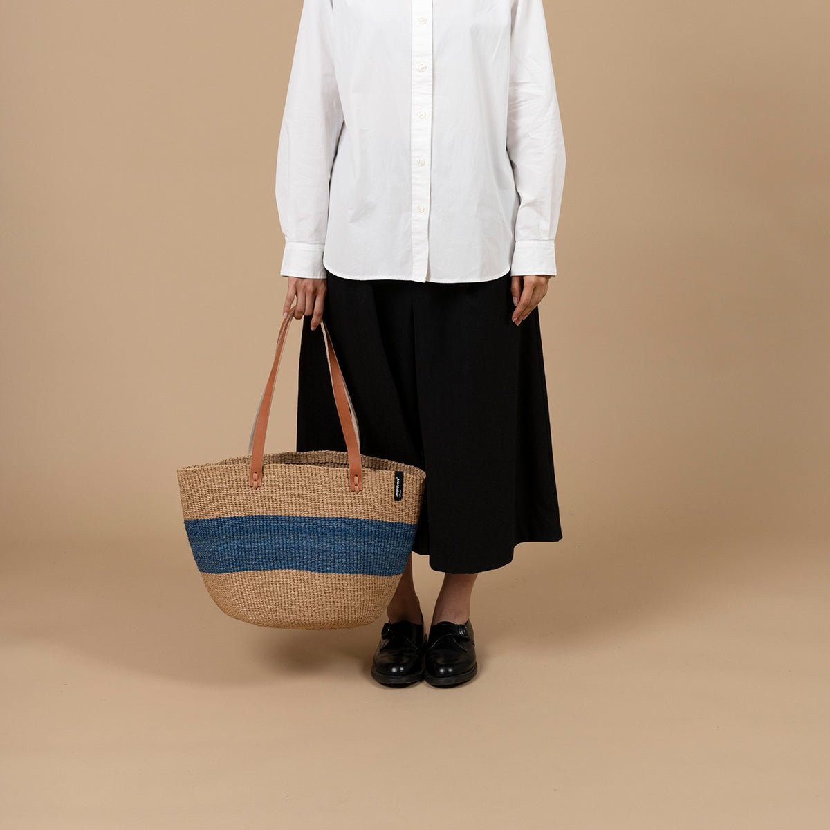 The Majani shopper basket is a beautiful and versatile accessory, handwoven with care using a combination of lightweight, durable paper fiber and soft, eco-friendly banana fiber