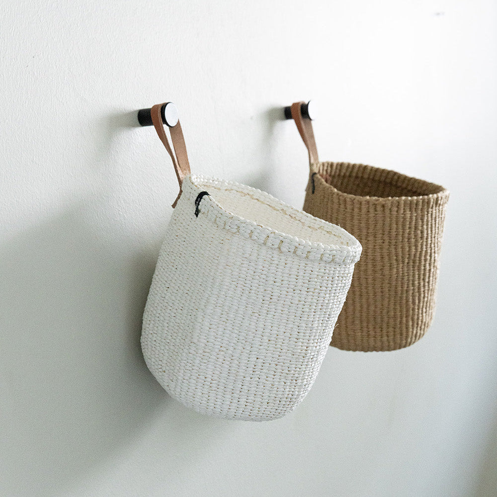 white and brown basket hanging with a 
leather loop