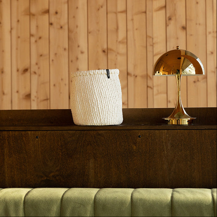 white small woven basket with brass design lamp