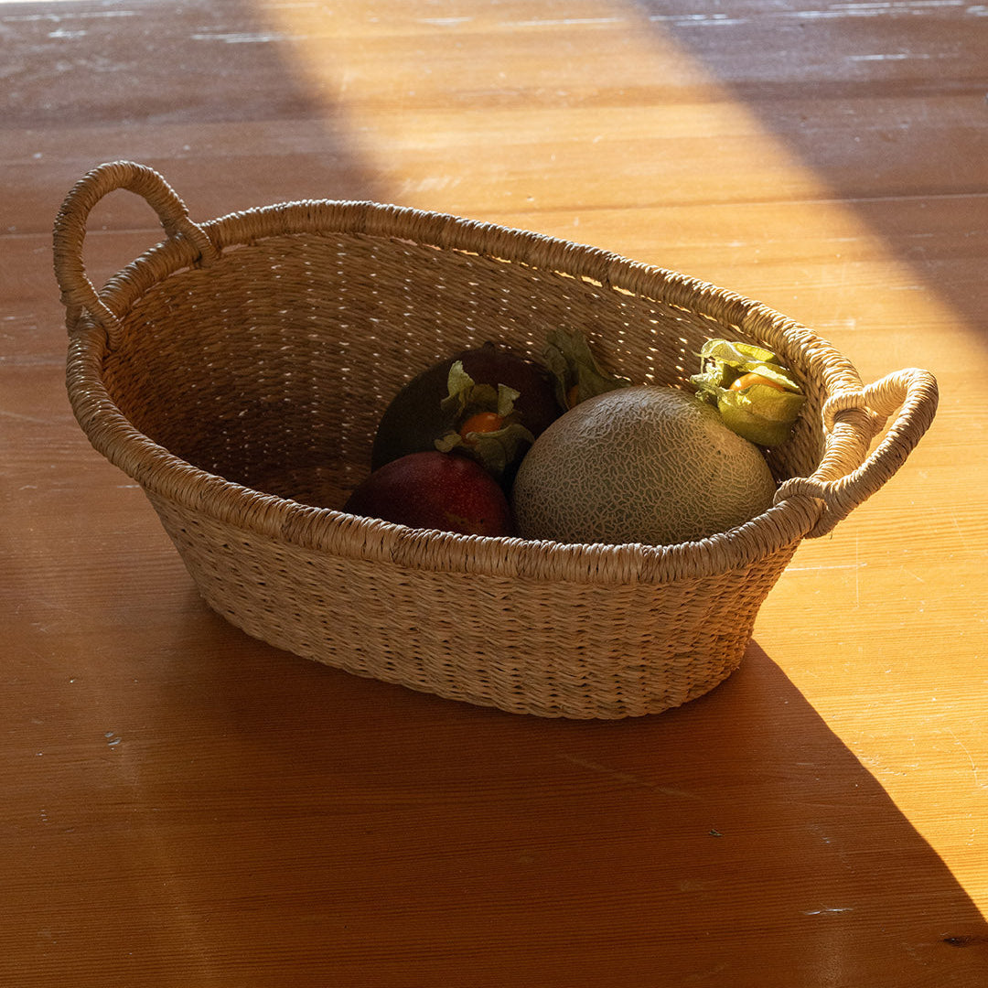 Wicker basket with fruits on a wooden table