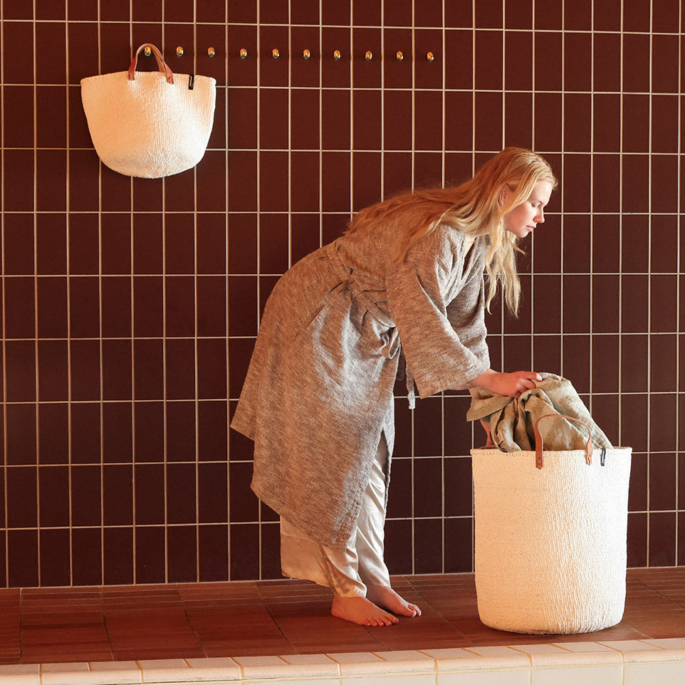 Woman with Beautiful white laundry basket with towel, handmade fair trade