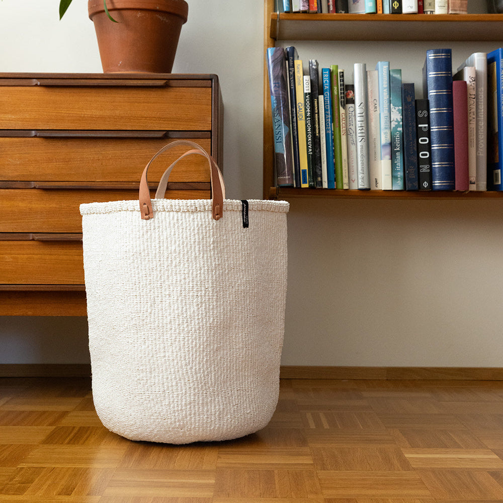 White woven basket in front of bookshelf