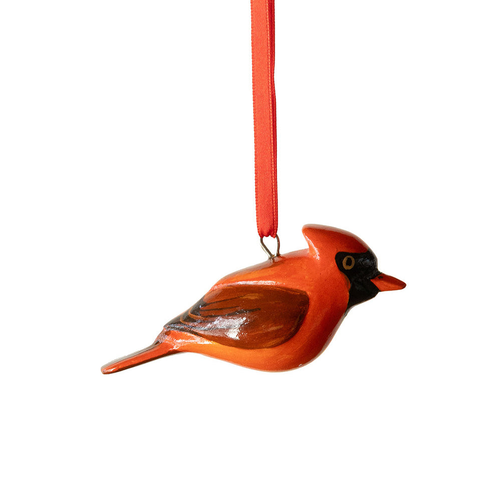 Decorative bird ornament with a red body and black head on a white background