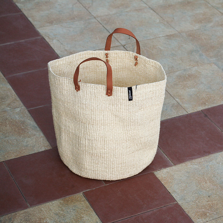 Beautiful handmade  sisal basket on a tile floor