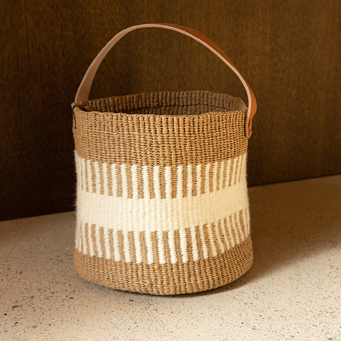 Woven basket with a handle on a neutral background