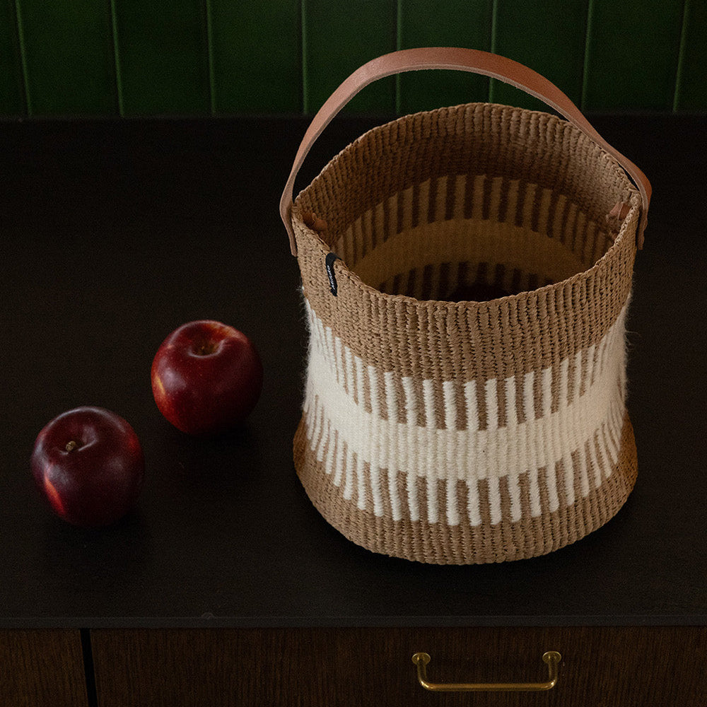 Woven basket with apples on a dark surface