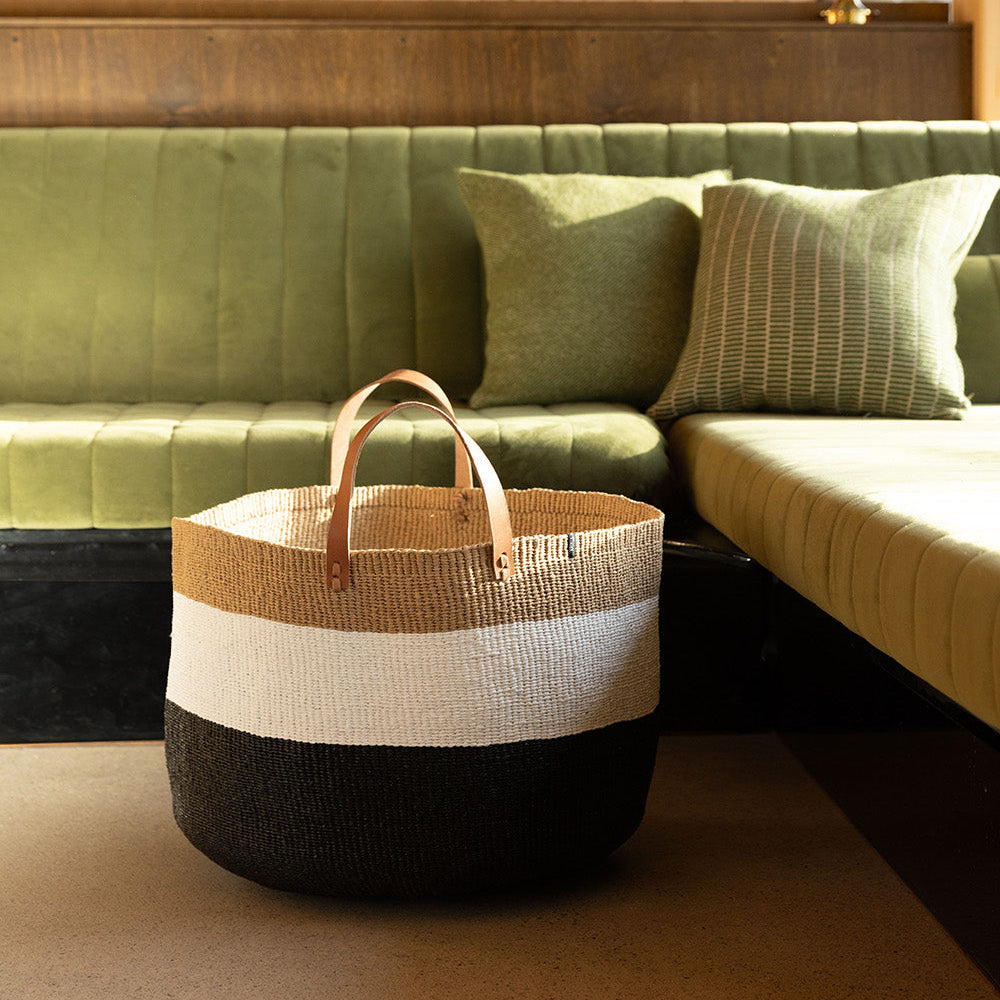 Beautiful floor basket duo black and white in front of green sofa
