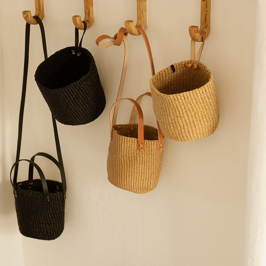 Woven baskets of various sizes hanging on a wall.