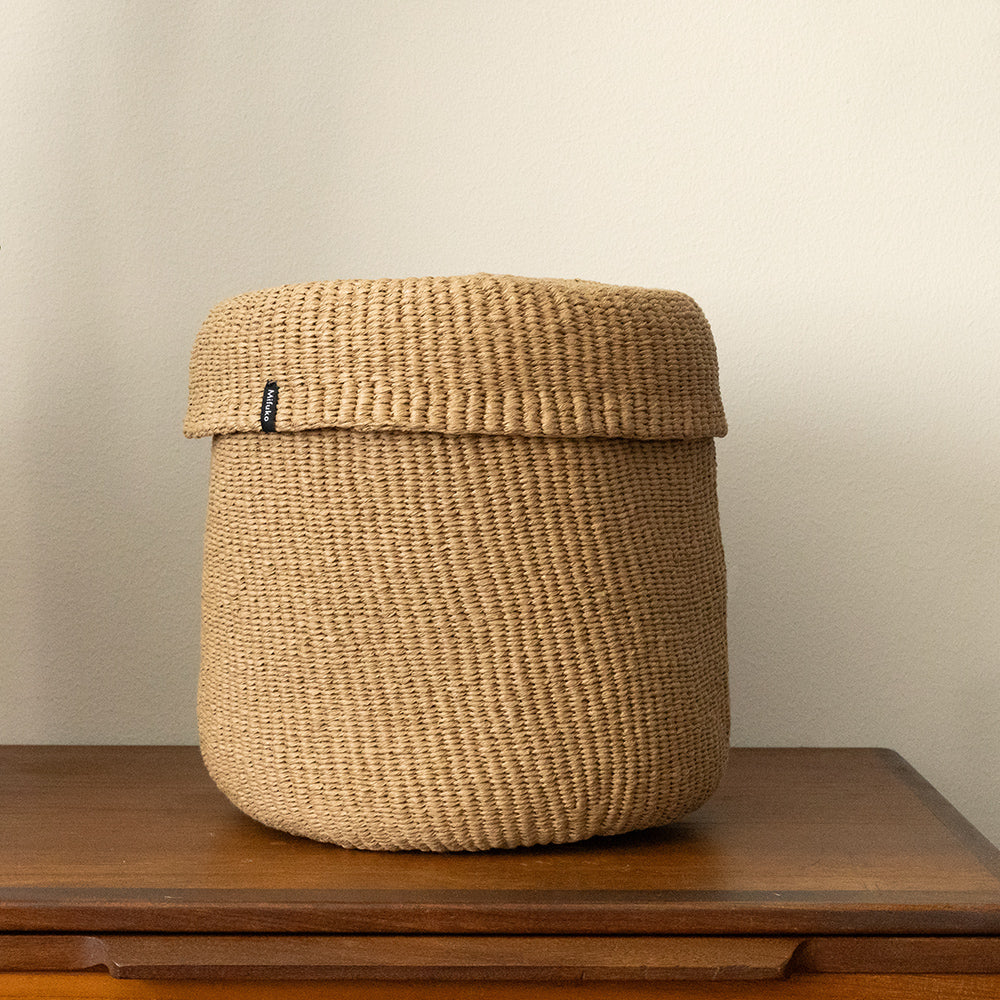 Woven basket with a lid on a wooden surface with a plain background