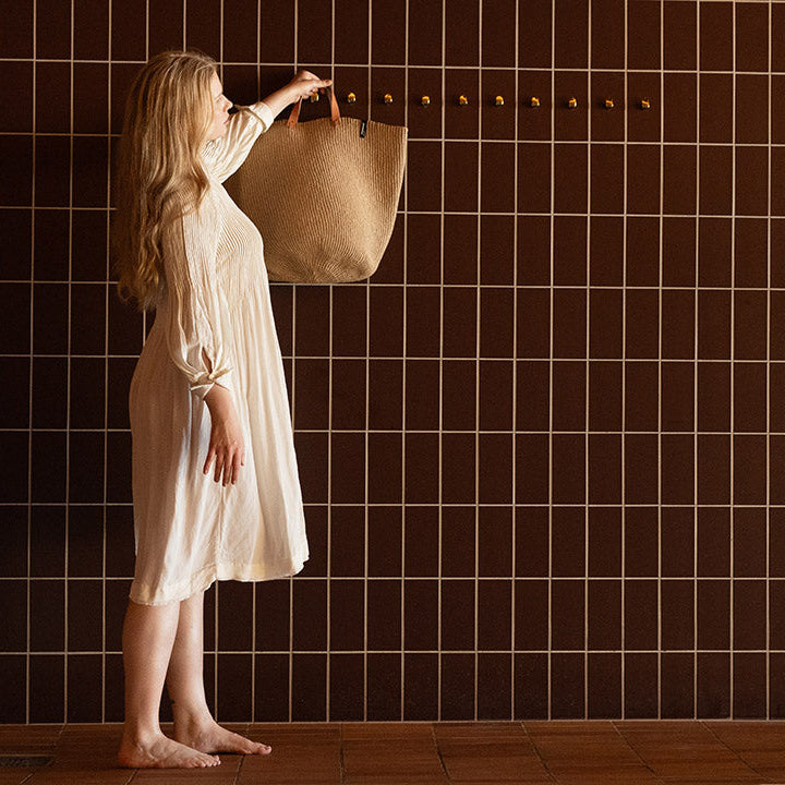 girl with a handwoven brown basket, dark brown tiles.