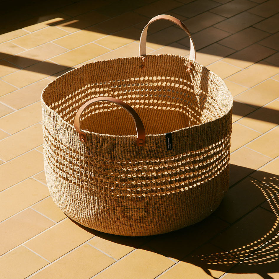 The Kiondo floor basket in brown open weave is a stylish and sustainable storage solution for your home. Handwoven with care by skilled artisans, this extra-large basket is crafted from FSC-certified paper, offering a lightweight yet durable design that is both functional and eco-friendly.
