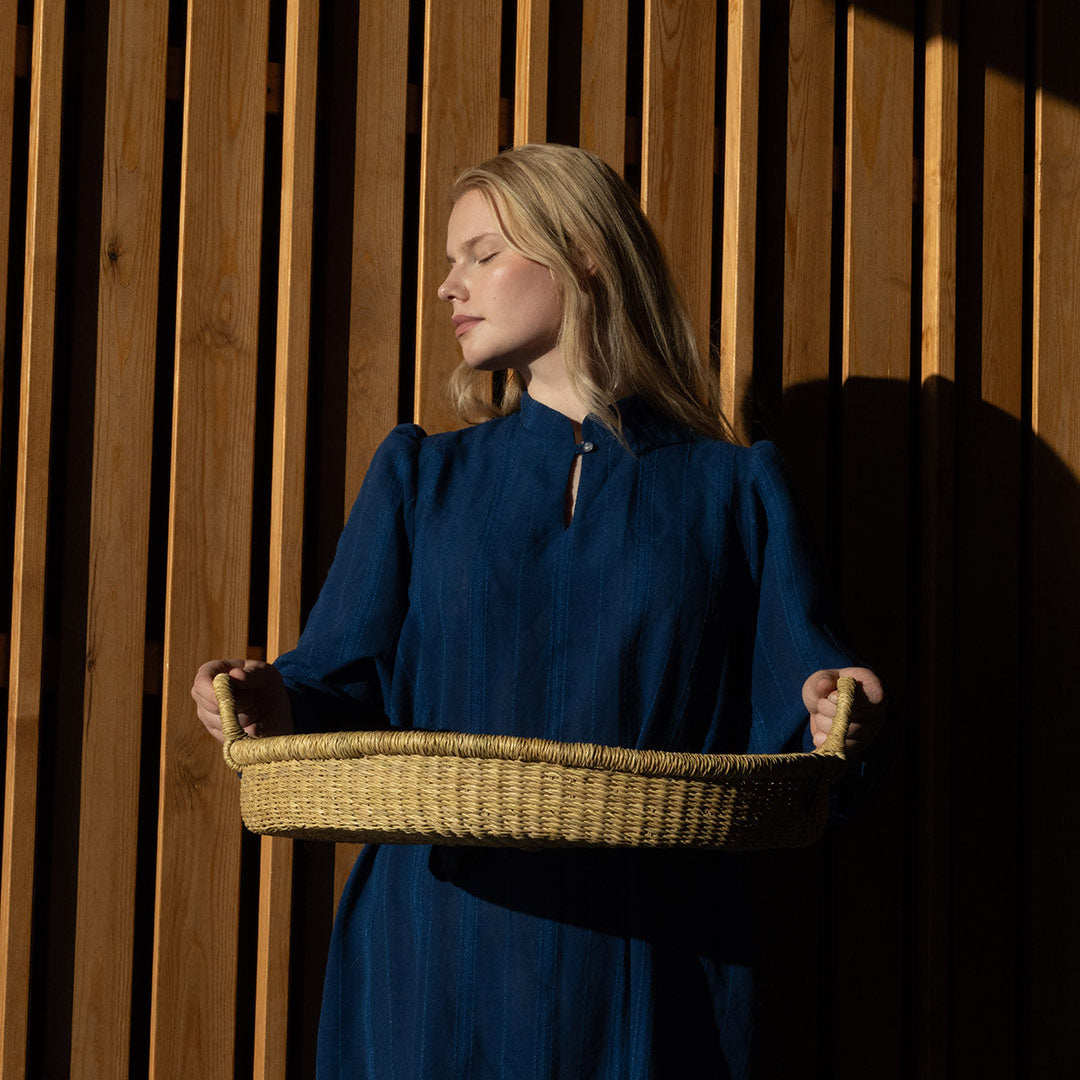 woman holding handmade natural tray in beautiful evening light. Fair trade.