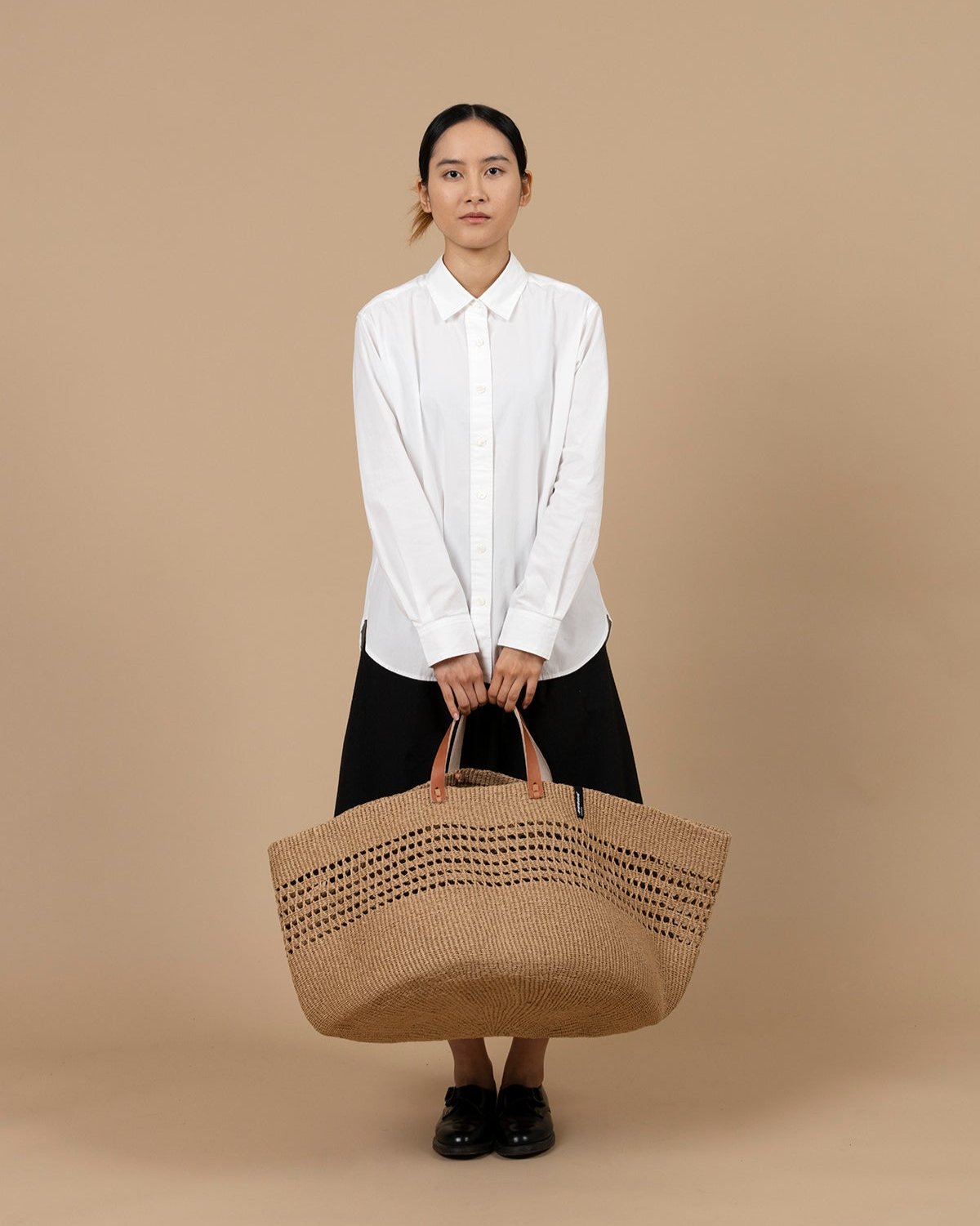 The Kiondo floor basket in brown open weave is a stylish and sustainable storage solution for your home. Handwoven with care by skilled artisans, this extra-large basket is crafted from FSC-certified paper, offering a lightweight yet durable design that is both functional and eco-friendly