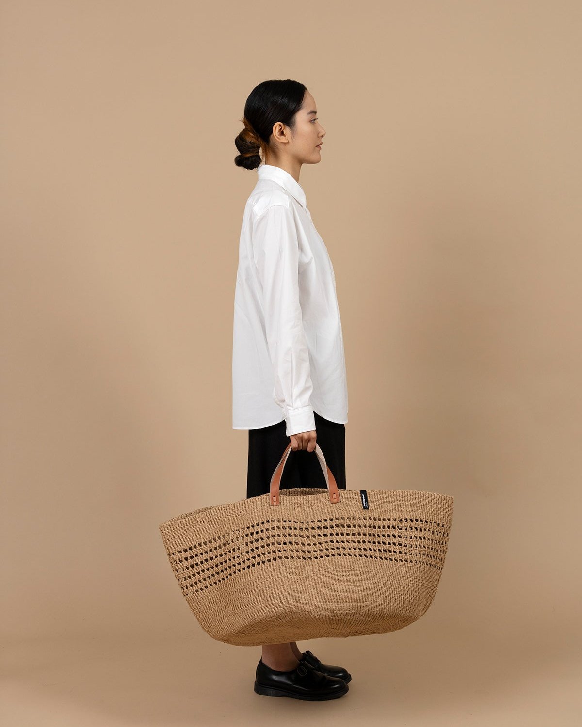 The Kiondo floor basket in brown open weave is a stylish and sustainable storage solution for your home. Handwoven with care by skilled artisans, this extra-large basket is crafted from FSC-certified paper, offering a lightweight yet durable design that is both functional and eco-friendly