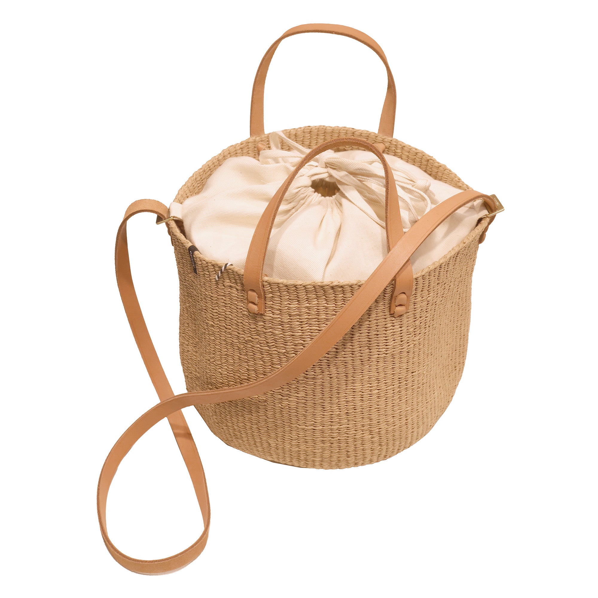 Woven basket with a beige drawstring bag on a white background