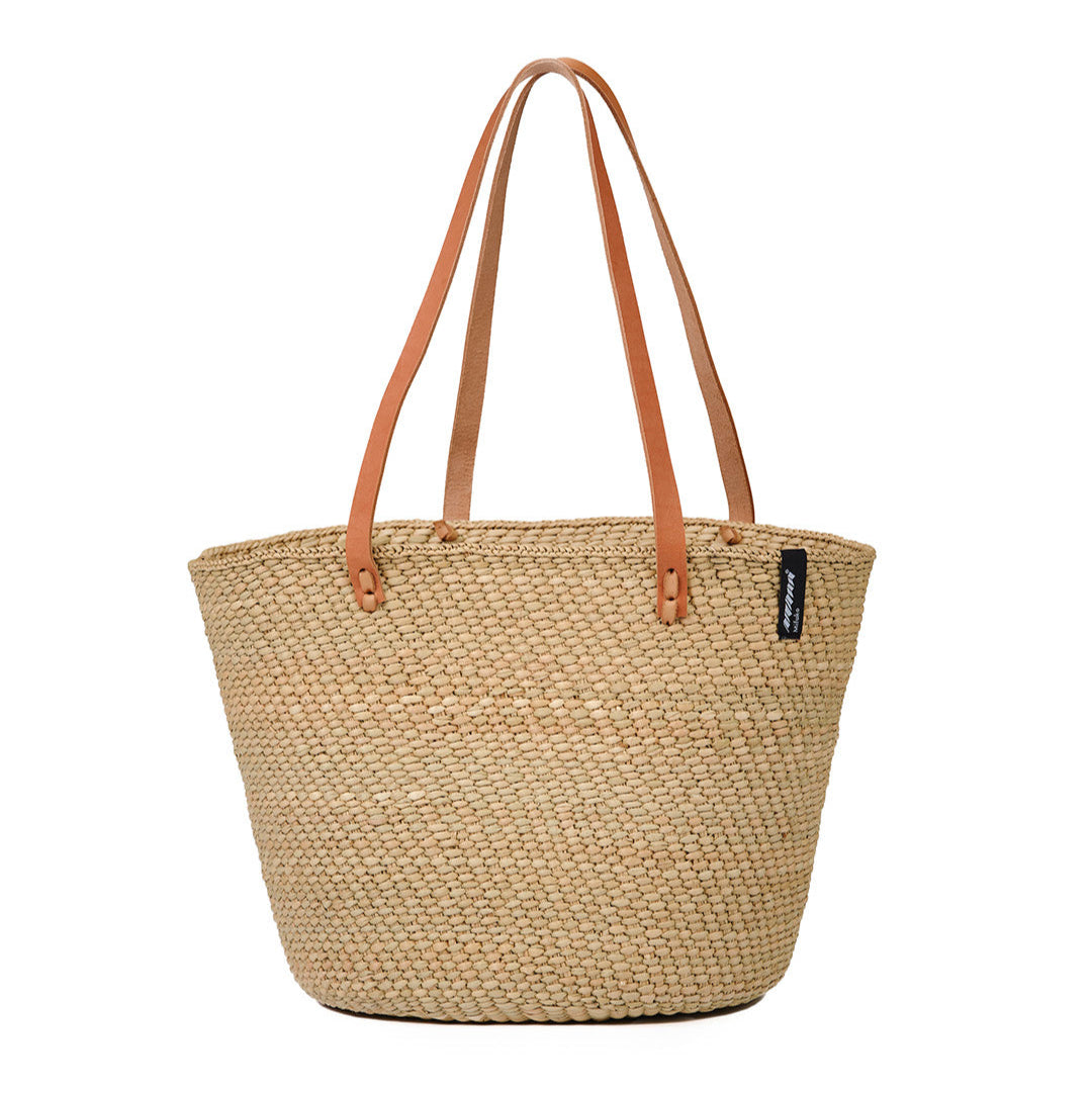 Beige  natural  handwoven tote bag with brown leather handles on a white background fair trade