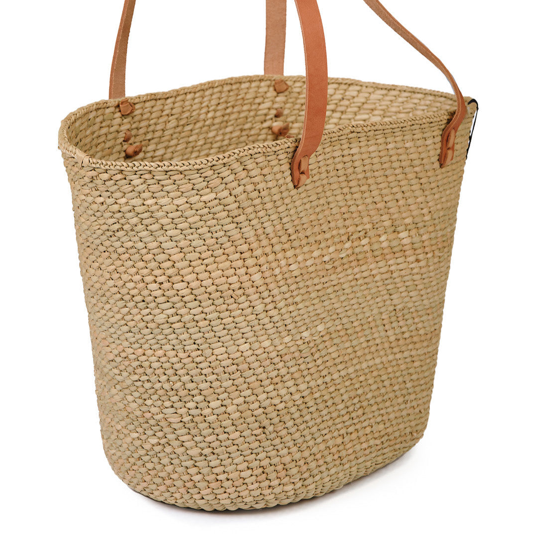 Beige  natural  handwoven tote bag with brown leather handles on a white background fair trade