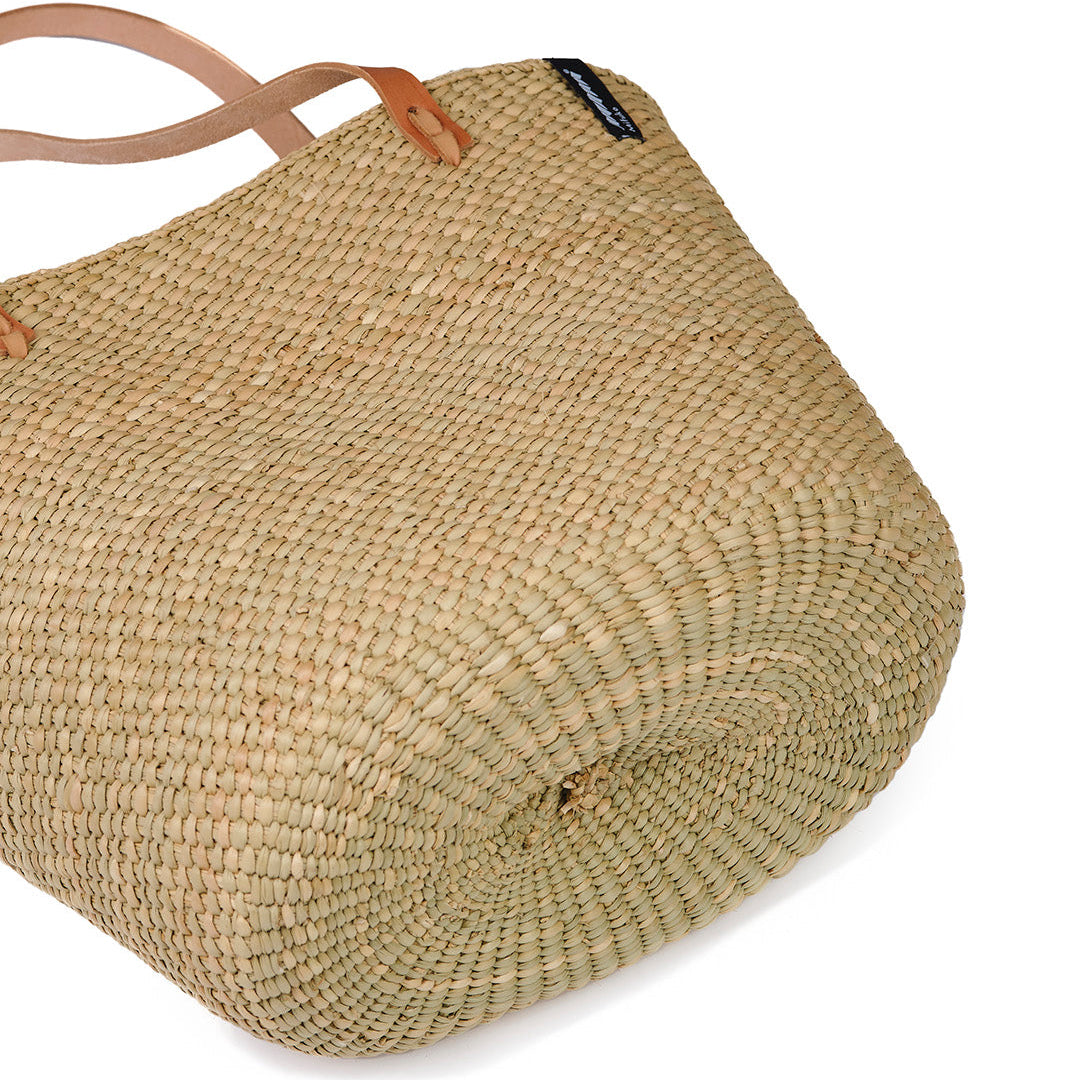 Beige  natural  handwoven tote bag with brown leather handles on a white background fair trade