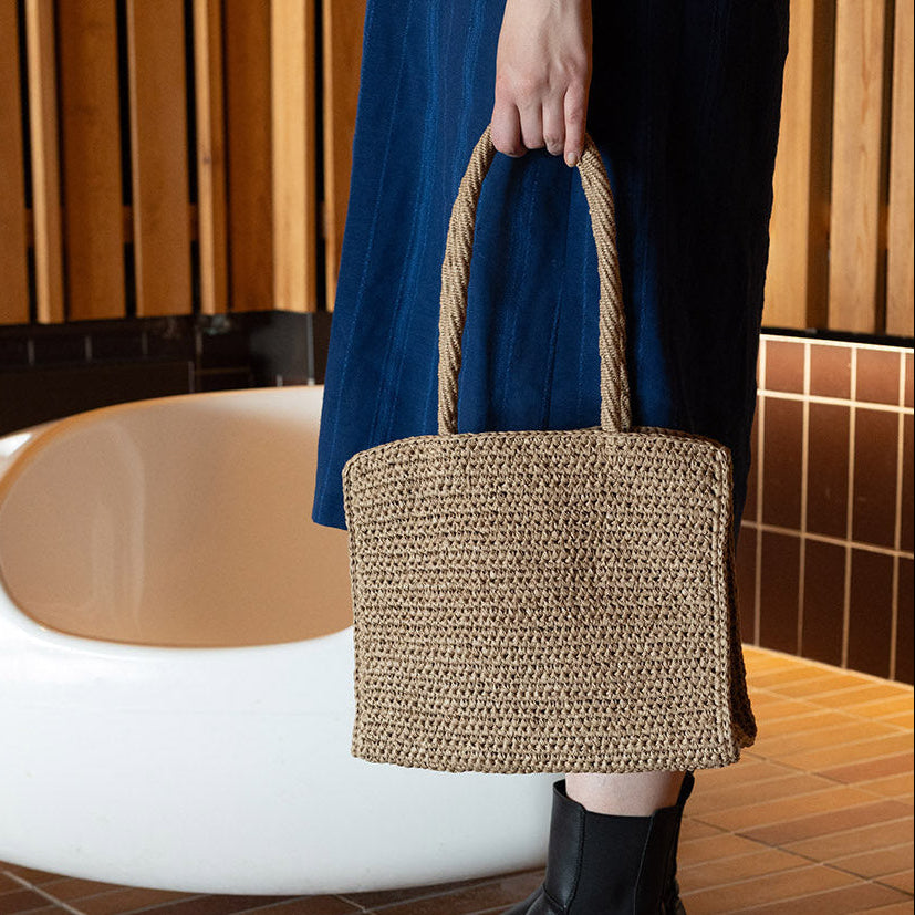 Woman with beautiful blue dress and crocheted brown bag