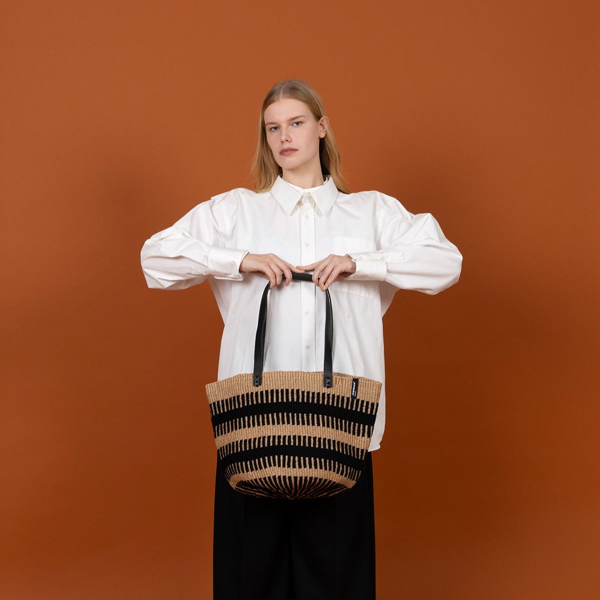 The Pamba shoulder bag is a stylish and durable accessory that combines functionality and elegance. Carefully handwoven, this bag stands out with its unique black rib weave, adding a modern touch to its timeless design.
