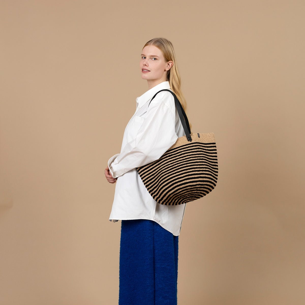The Pamba shopper basket is a perfect blend of style, functionality, and sustainability. Handwoven with care, this medium-sized basket features a chic black thin stripe design, adding a touch of sophistication to its timeless look.

Crafted from natural and durable materials, the Pamba shopper is ideal for shopping, carrying everyday essentials, or serving as a stylish storage solution. Its long black handles offer comfort and practicality, making it easy to carry whether you’re running errands or heading t
